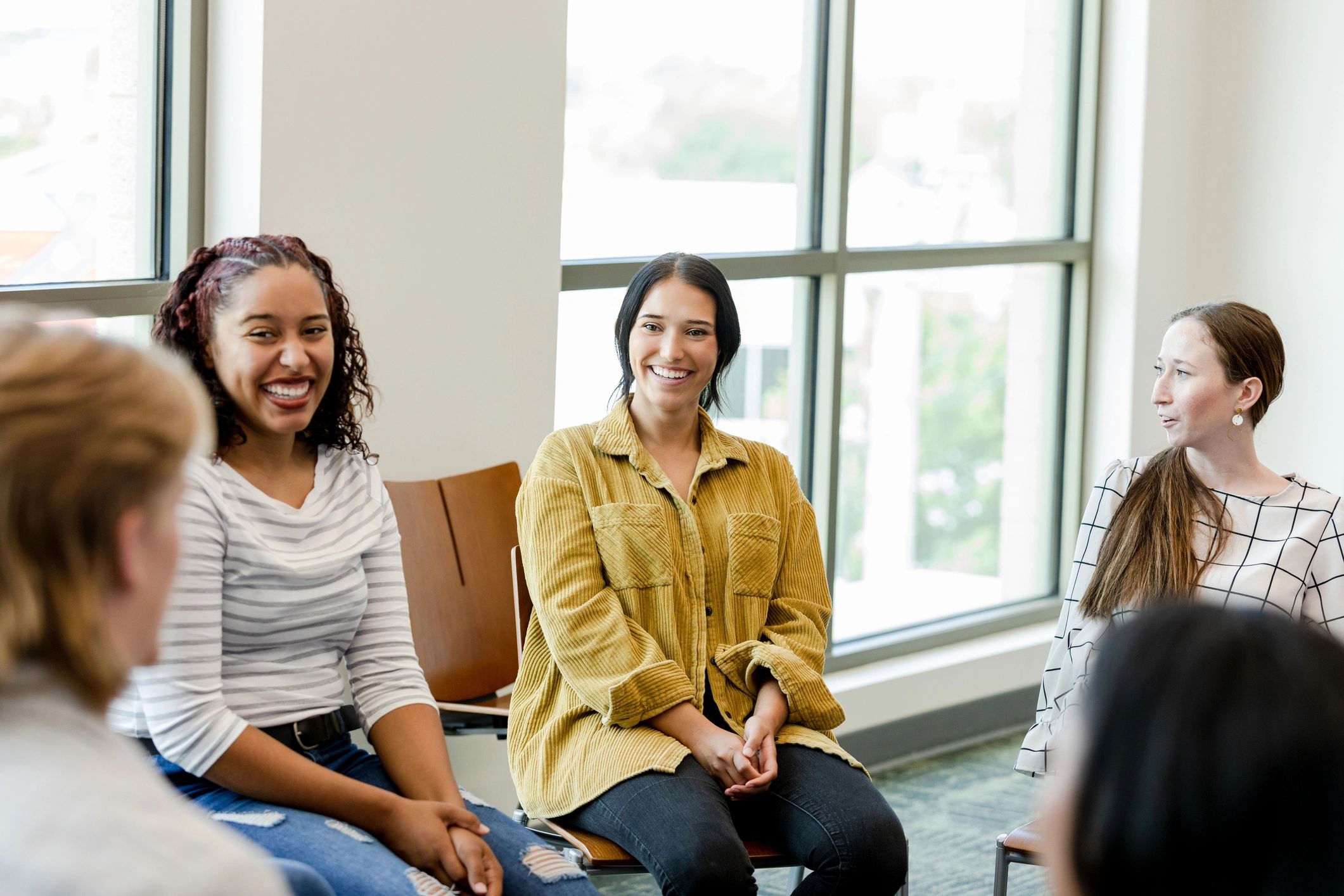 Young adults gathered together in a supportive group setting
