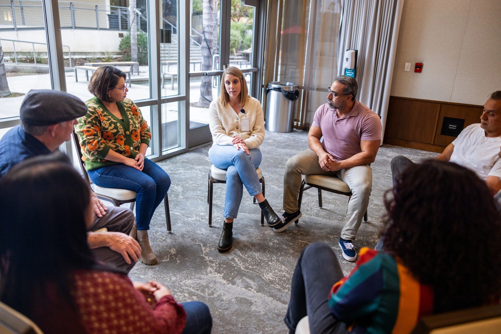 Wide shot of a small group discussion being led by a mature woman